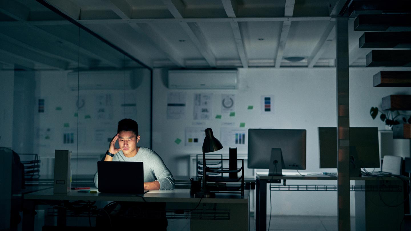 photo of person sitting in a dark room on a computer