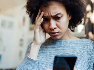 Image of a person looking at their phone with a worried expression