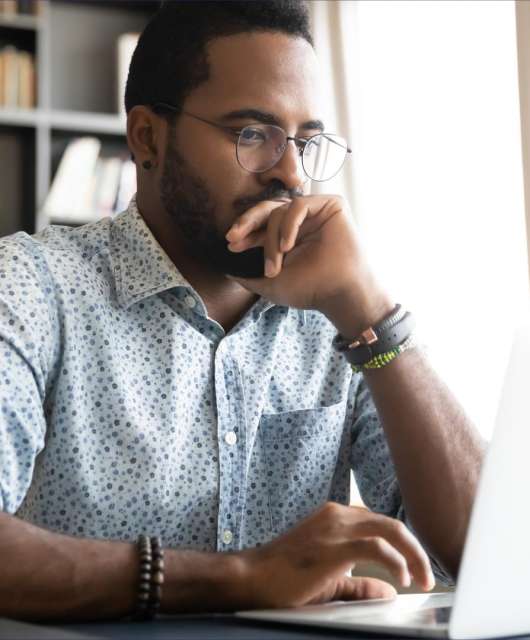 Man sitting and looking at a laptop.