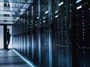 Person standing at the end of a hallway of computer servers.