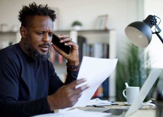 Worried man talking on the phone while working from home