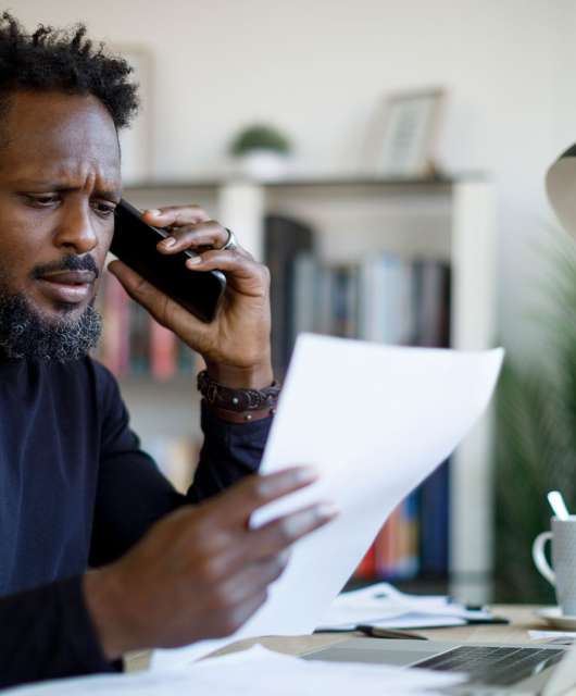 Worried man talking on the phone while working from home