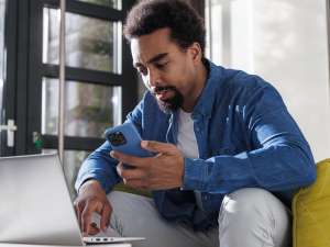 Man researching 888 area code number on laptop.