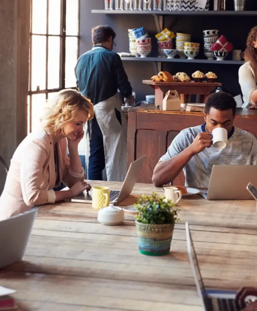 A busy cafe with many people connecting to Wi-Fi on laptops