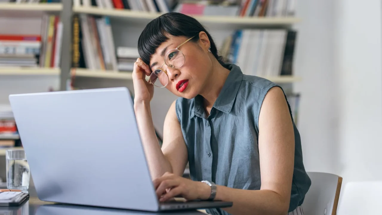 A stock photo of a woman using a laptop to browse websites.