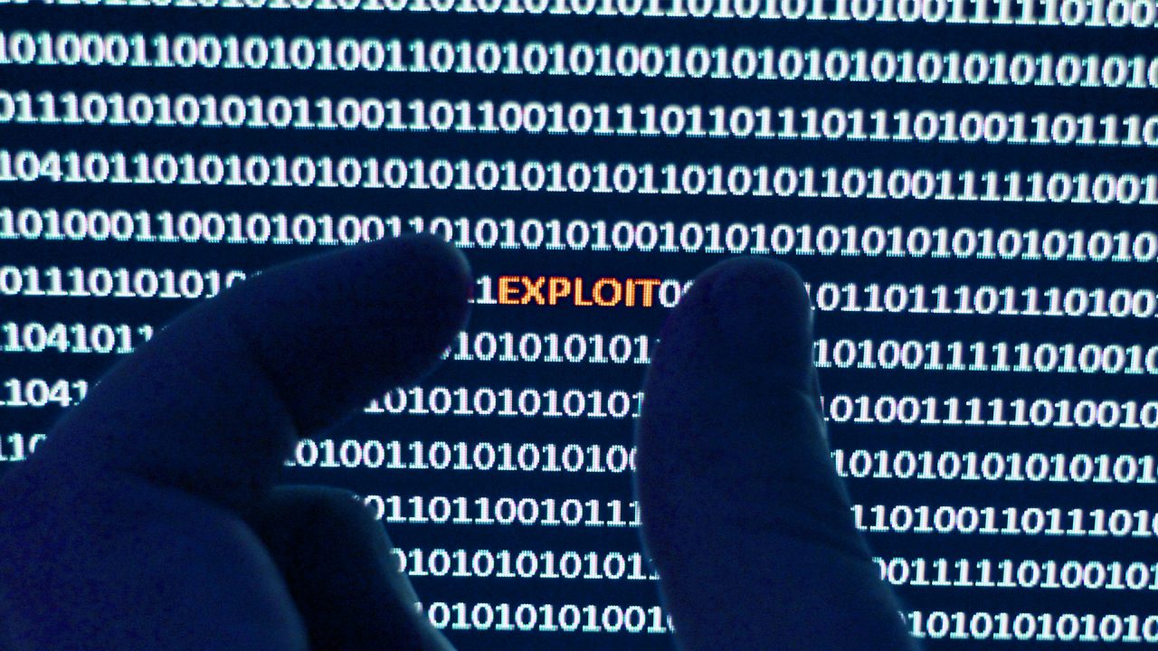 A pair of fingers extracting computer software exploit from a string of binary code.