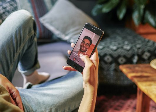 Stock photo of someone viewing a suspicious-looking dating profile.