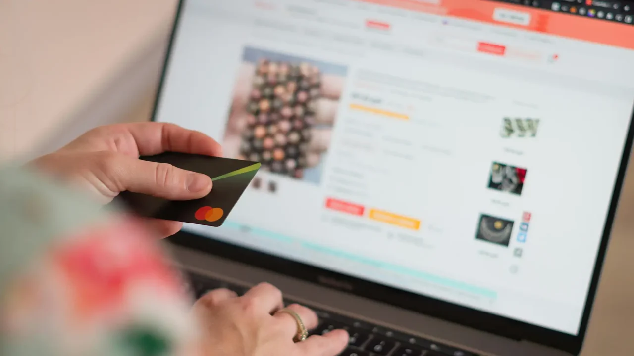 A photo of someone using a laptop with a fake online marketplace on it that they believe to be Temu.