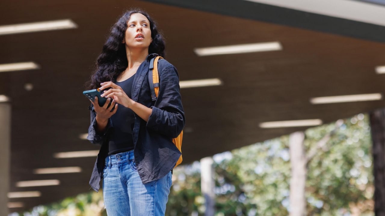 A woman checking her phone in an outdoor location.
