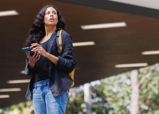 A woman checking her phone in an outdoor location.
