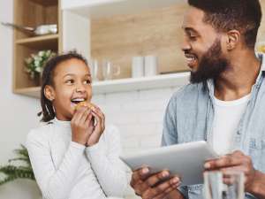 girl-eating-cookie-dad-on-ipad